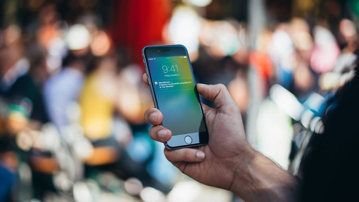 Attractions.io hand using mobile app with blurred background