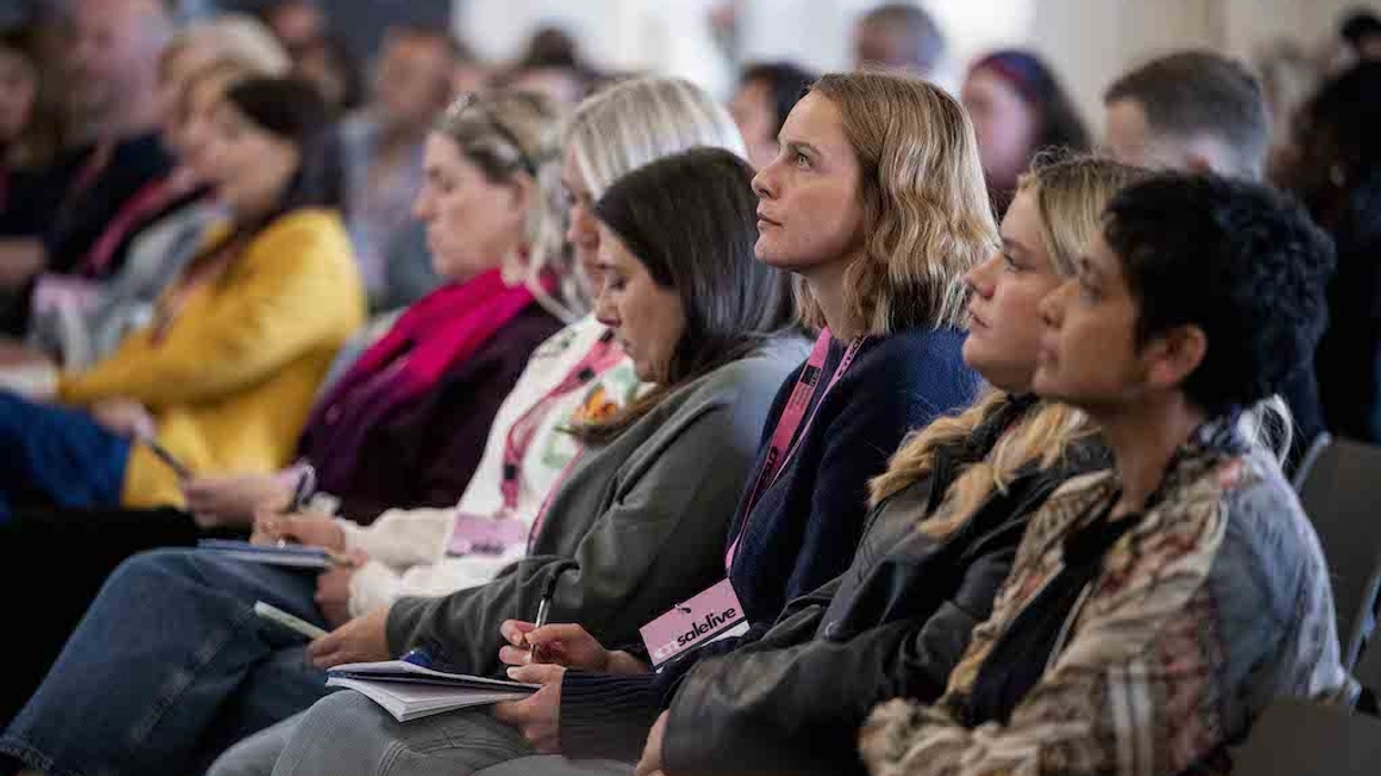 Audience attentively listening at On Sale Live conference, taking notes.