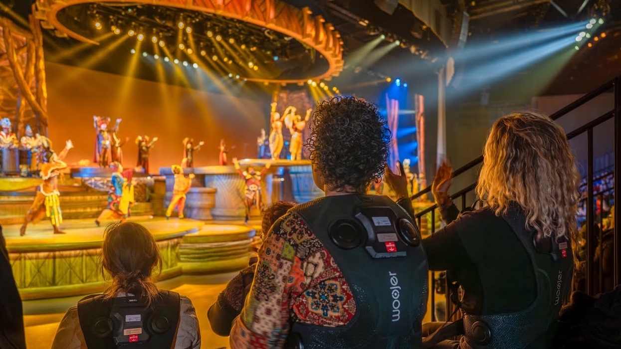 Audience members wearing vests that turn sound into vibrations during The Lion King: Rhythms of the Pride Lands at Disneyland Paris