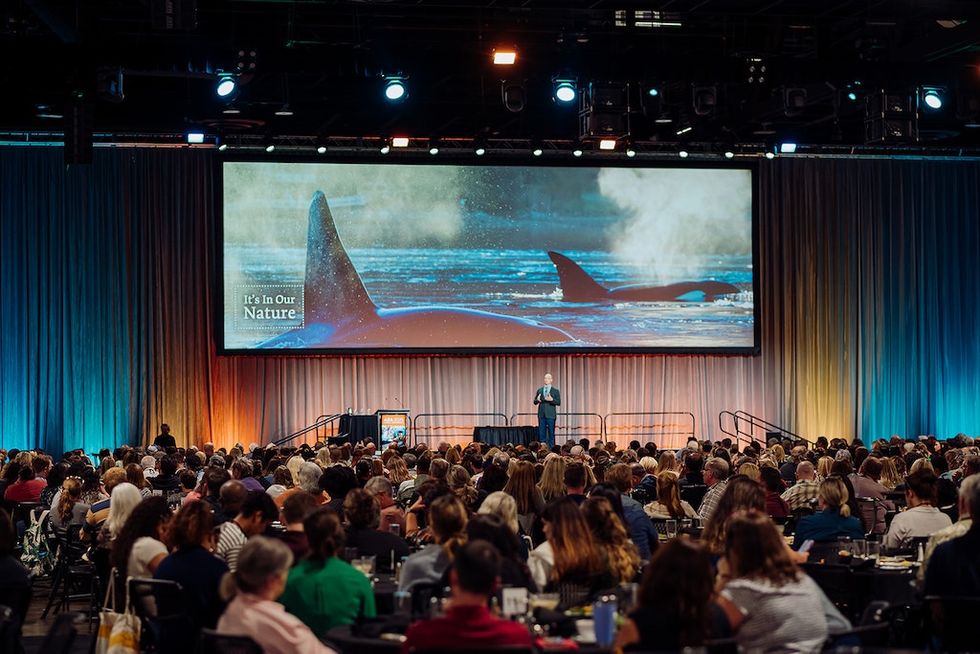 AZA Annual Conference with a keynote speaker on stage; screen shows "It's In Our Nature" with orcas.