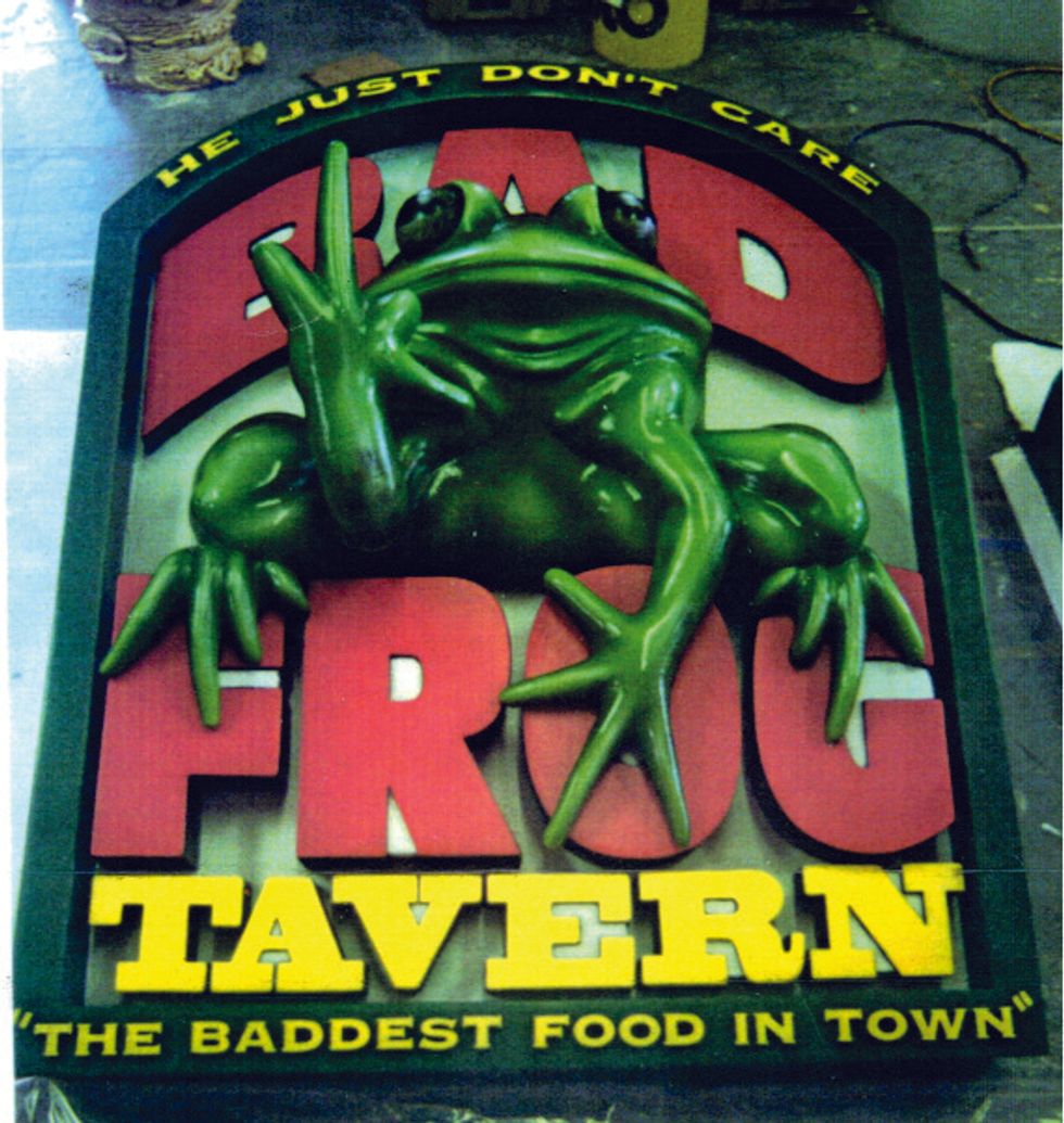 "Bad Frog Tavern sign with a frog making a peace sign on bold text background."