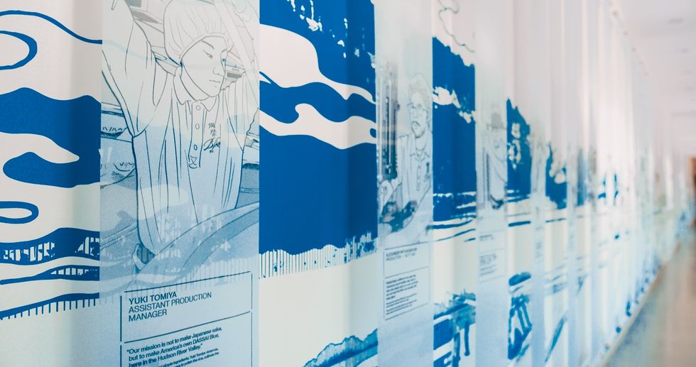 Blue and white mural on a hallway wall, featuring abstract and industrial-themed graphics.