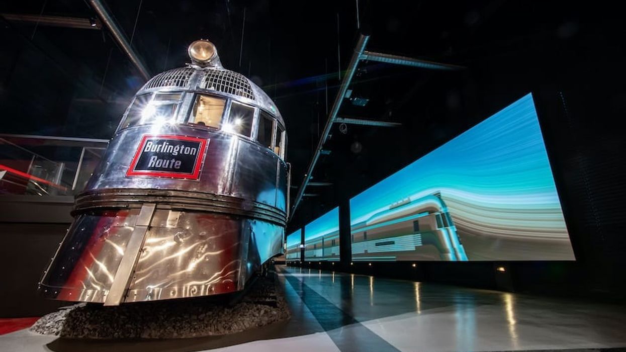 Blue LED displays down hallway with chrome passenger train at left