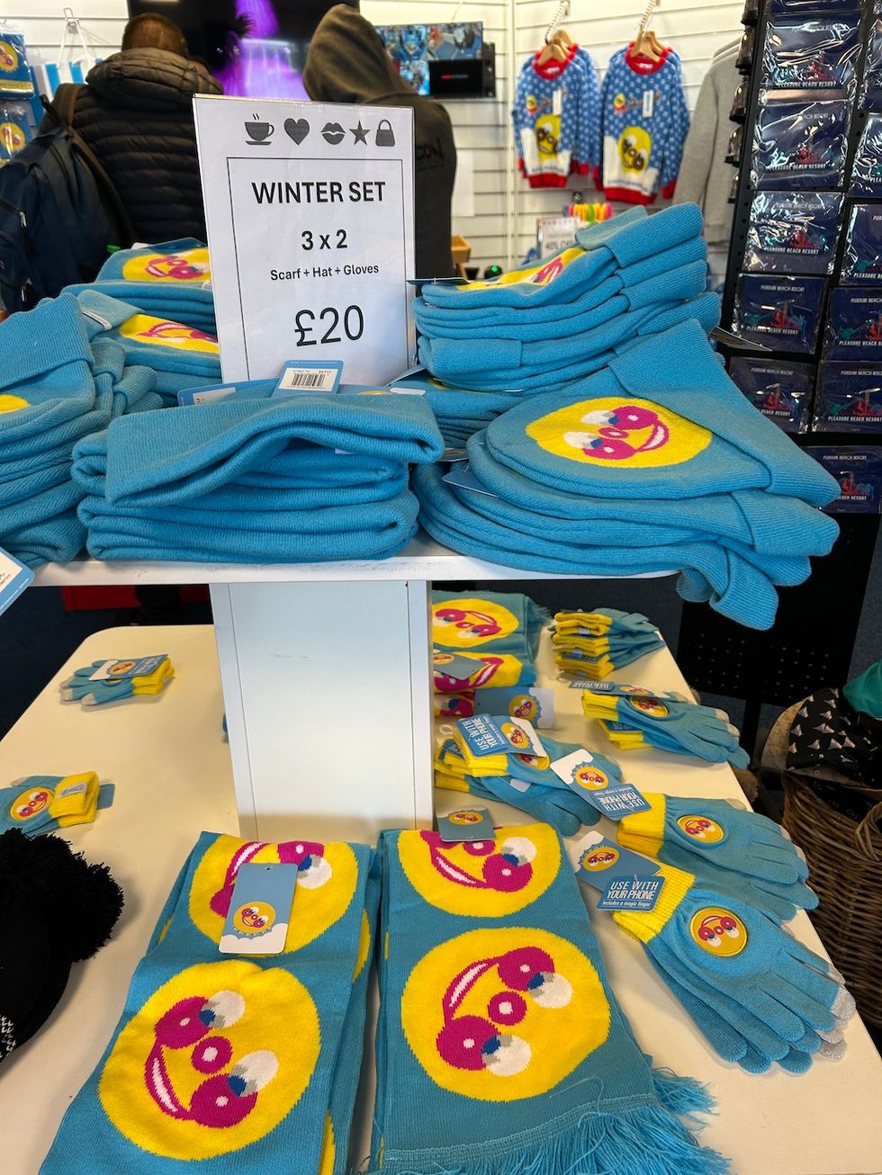 Blue winter sets with smiley design and price sign in a store display.