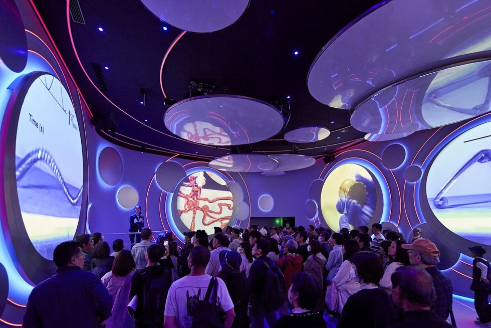 BRC, USA Pavilion at Expo Osaka 2025 Futuristic room with circular screens, crowd gathered for a presentation or show.