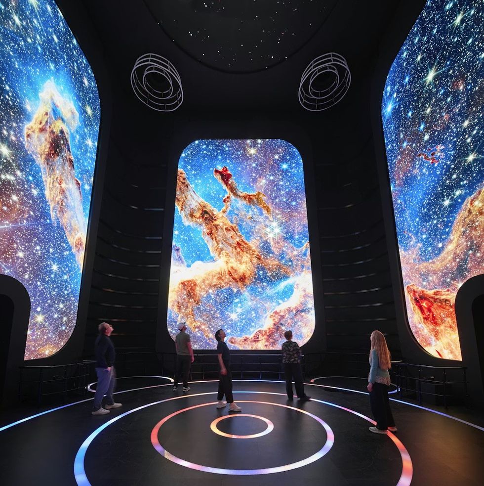 BRC, USA Pavilion at Expo Osaka 2025 People viewing cosmic scenes on large screens in a dark, immersive room.