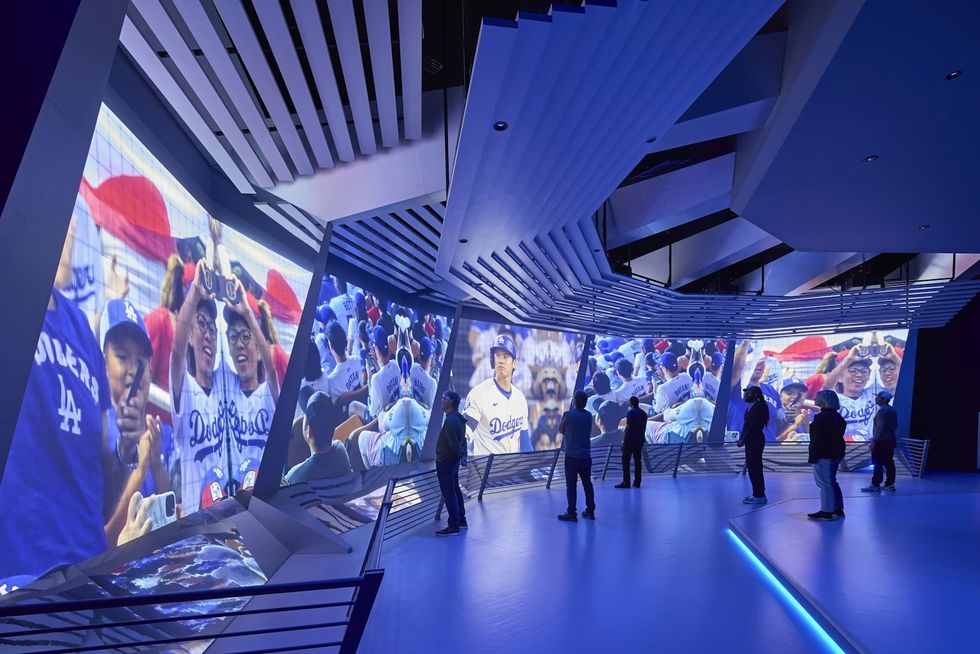 BRC, USA Pavilion at Expo Osaka 2025 People viewing Dodgers baseball images on large, angled screens in a modern exhibit space.