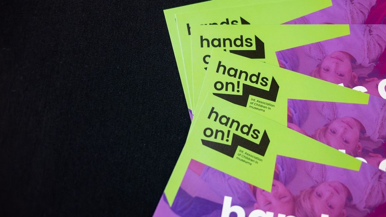 Bright flyers with "hands on!" text on a black surface.