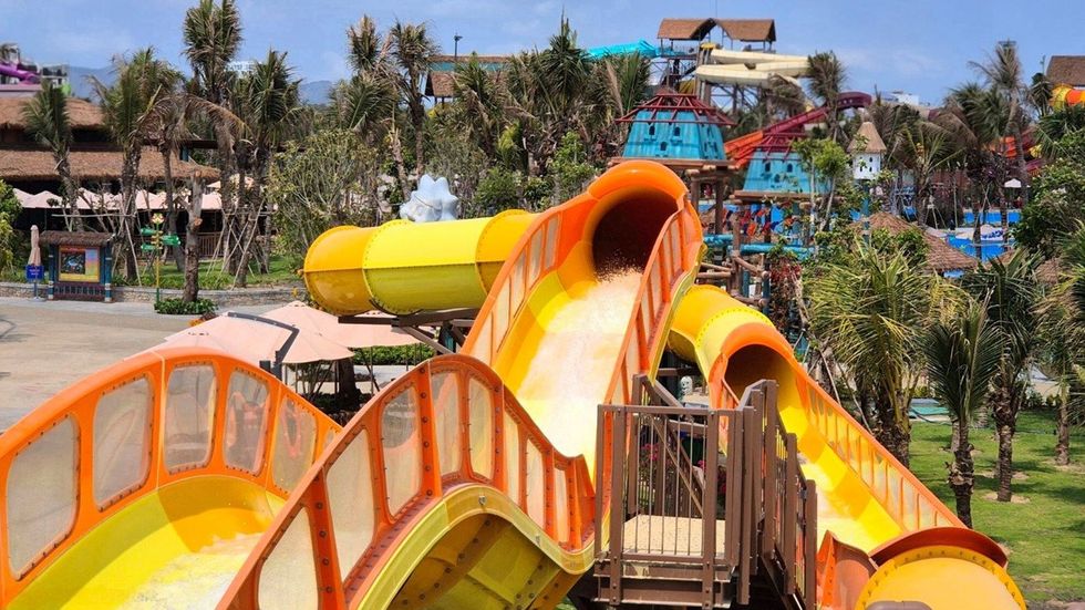 Bright orange water slides at a lively outdoor water park.