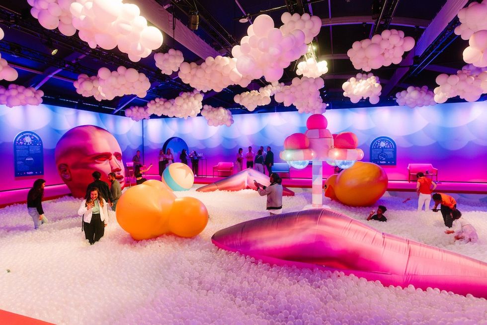 Bubble Planet: An Immersive Experience: Colorful playroom with balloons, giant sculptures, and people enjoying a ball pit.