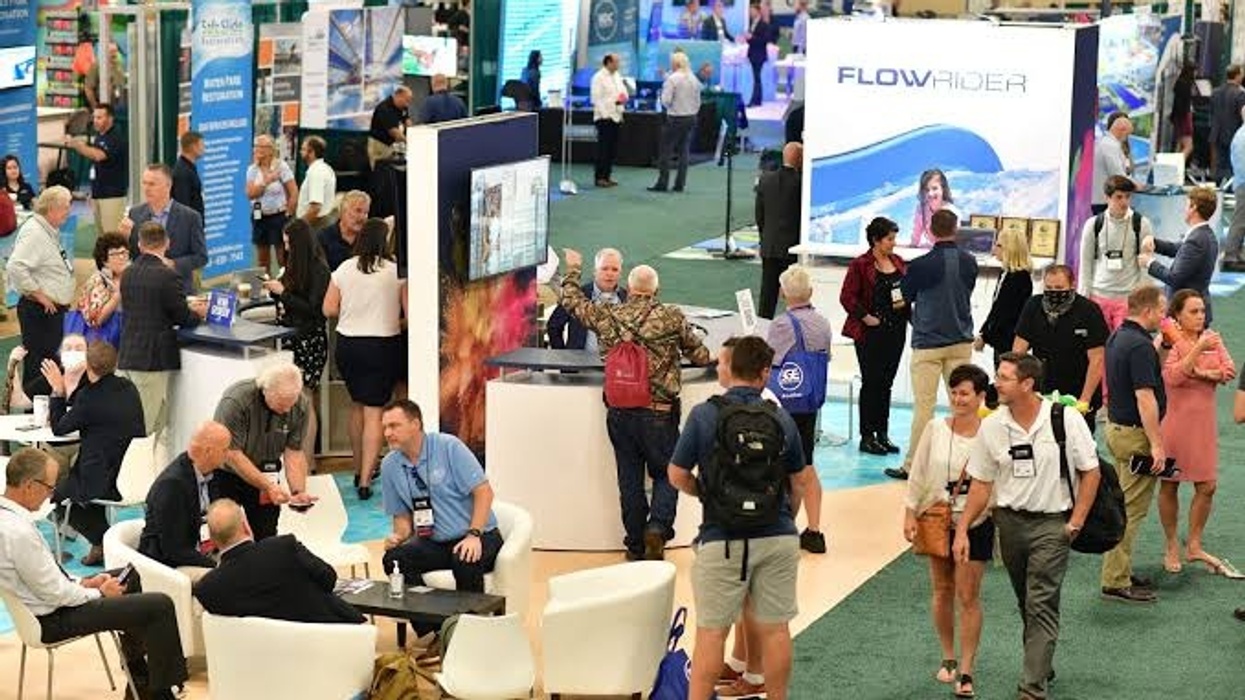 Busy convention floor with people networking and visiting booths.