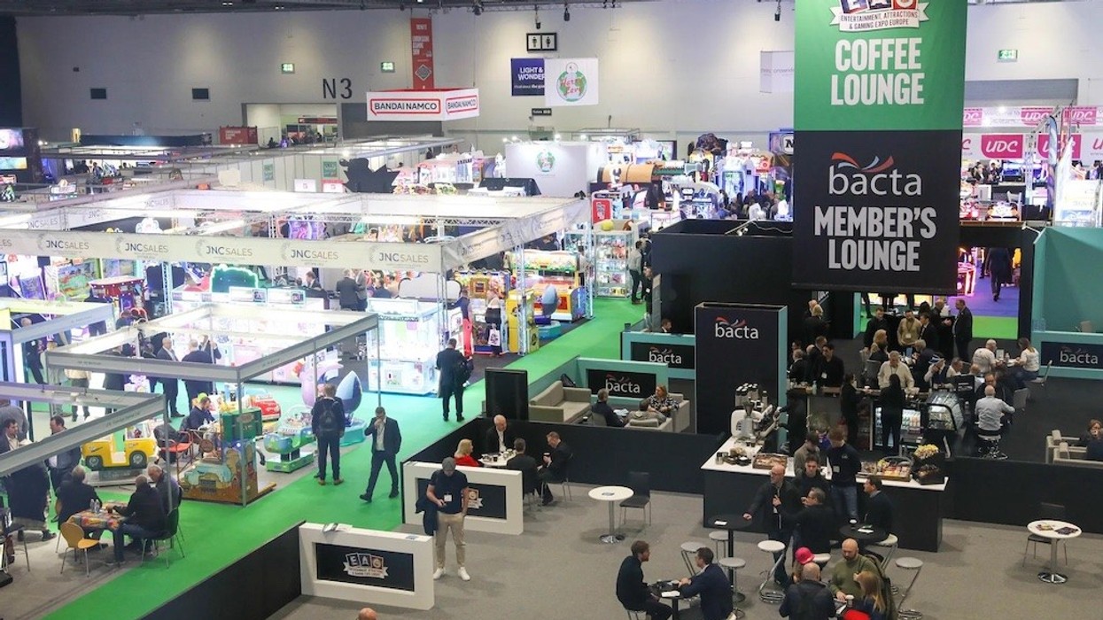 Busy gaming expo hall with booths, people, and a large "Coffee Lounge" sign overhead.