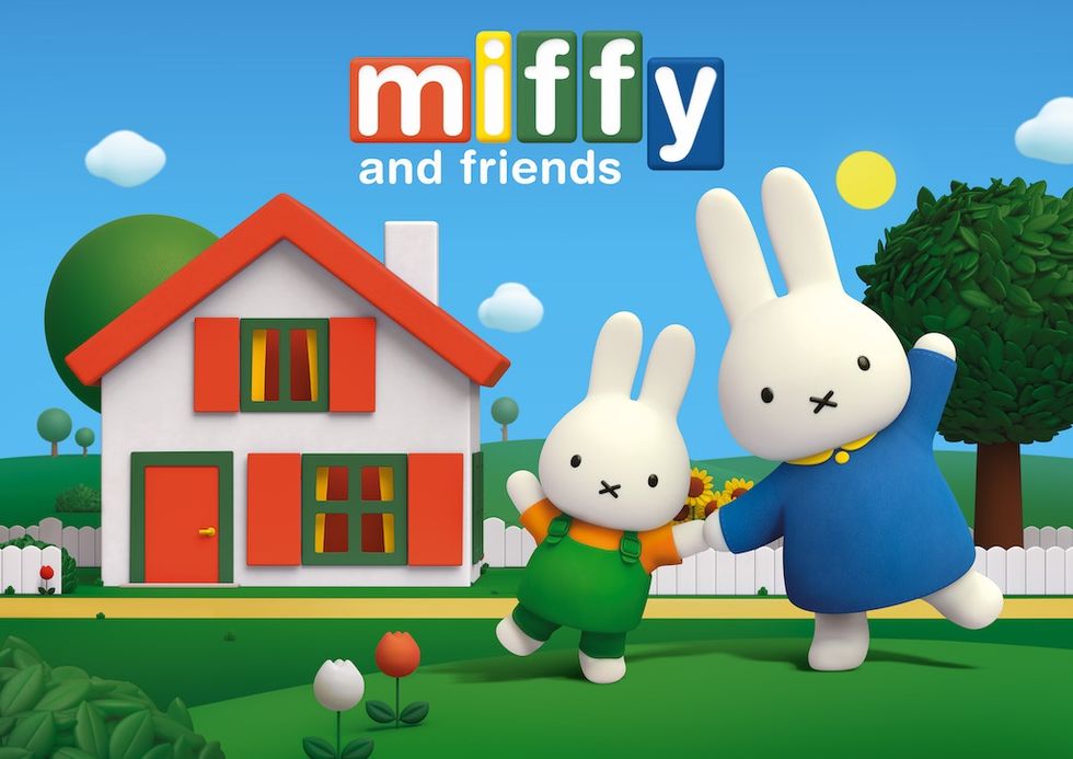 Cartoon bunnies Miffy and Friends dancing in a sunny yard with a small house and trees.
