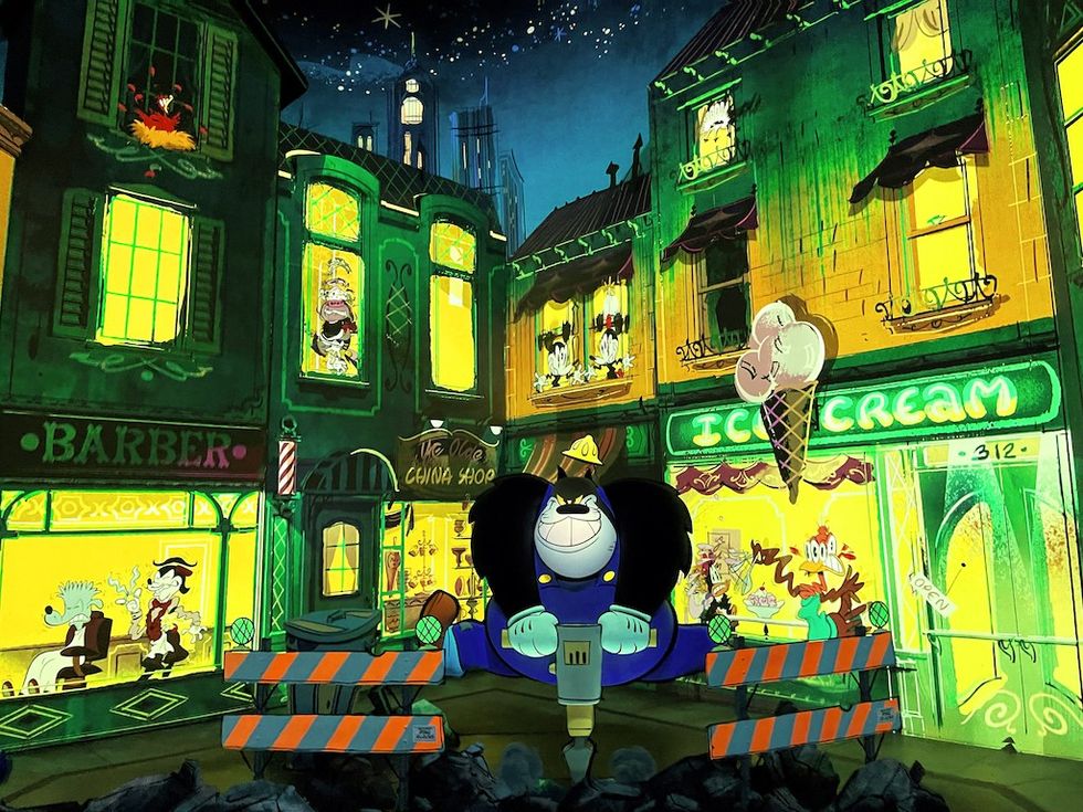 Cartoon character with a jackhammer on a colorful street at night.
