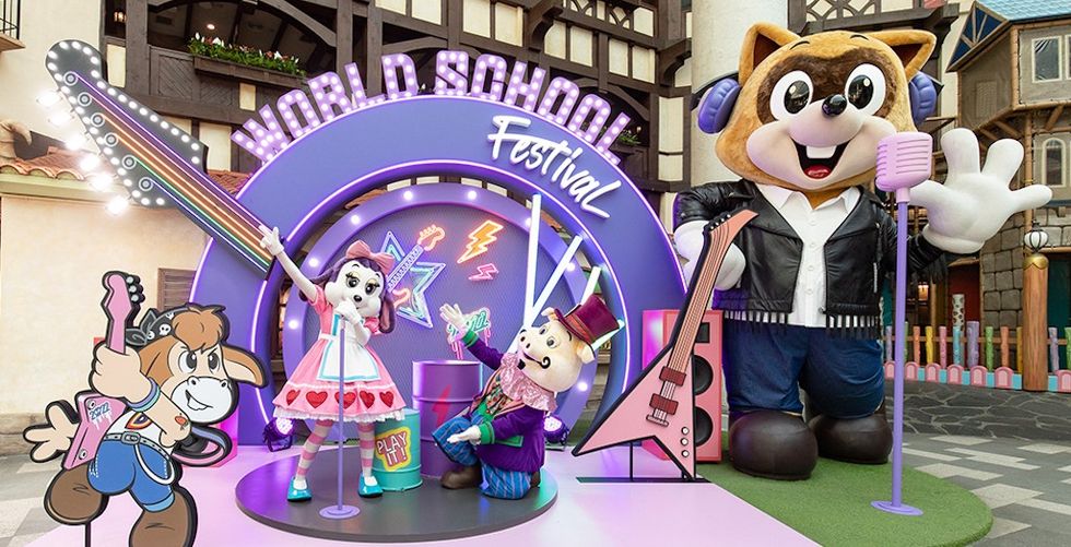 Cartoon characters perform at "World School Festival" with guitars and bright backdrop.