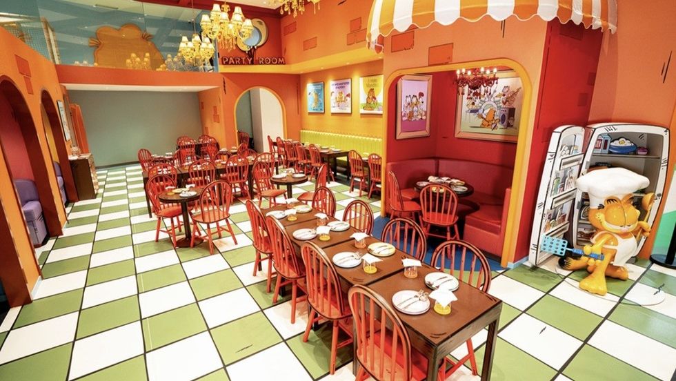Cartoon-themed cafe with colorful decor and dining tables set for guests.