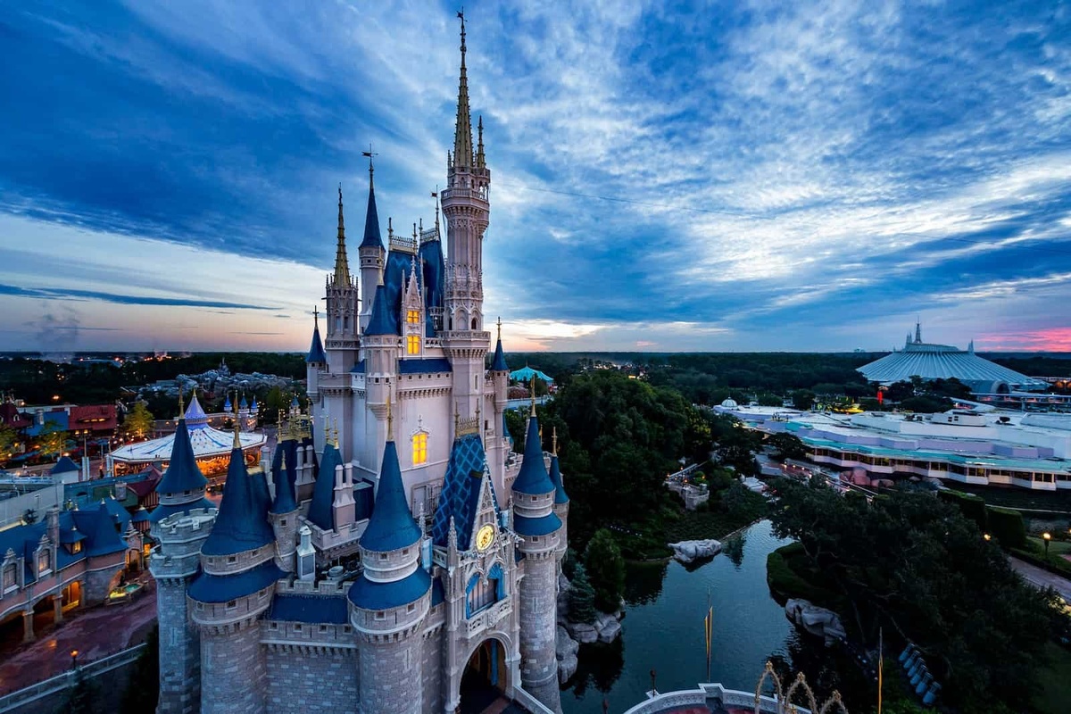 Castle at Disney World's Magic Kingdom theme park with a stunning sunset and vibrant sky in the background.