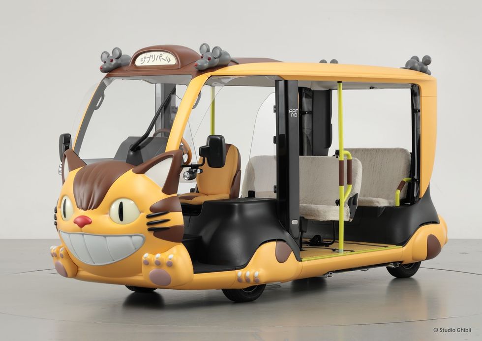 Cat-shaped bus with fluffy seats and mouse decorations.