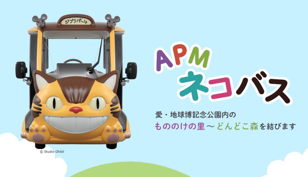 Catbus-themed vehicle with colorful Japanese text on a light blue background.