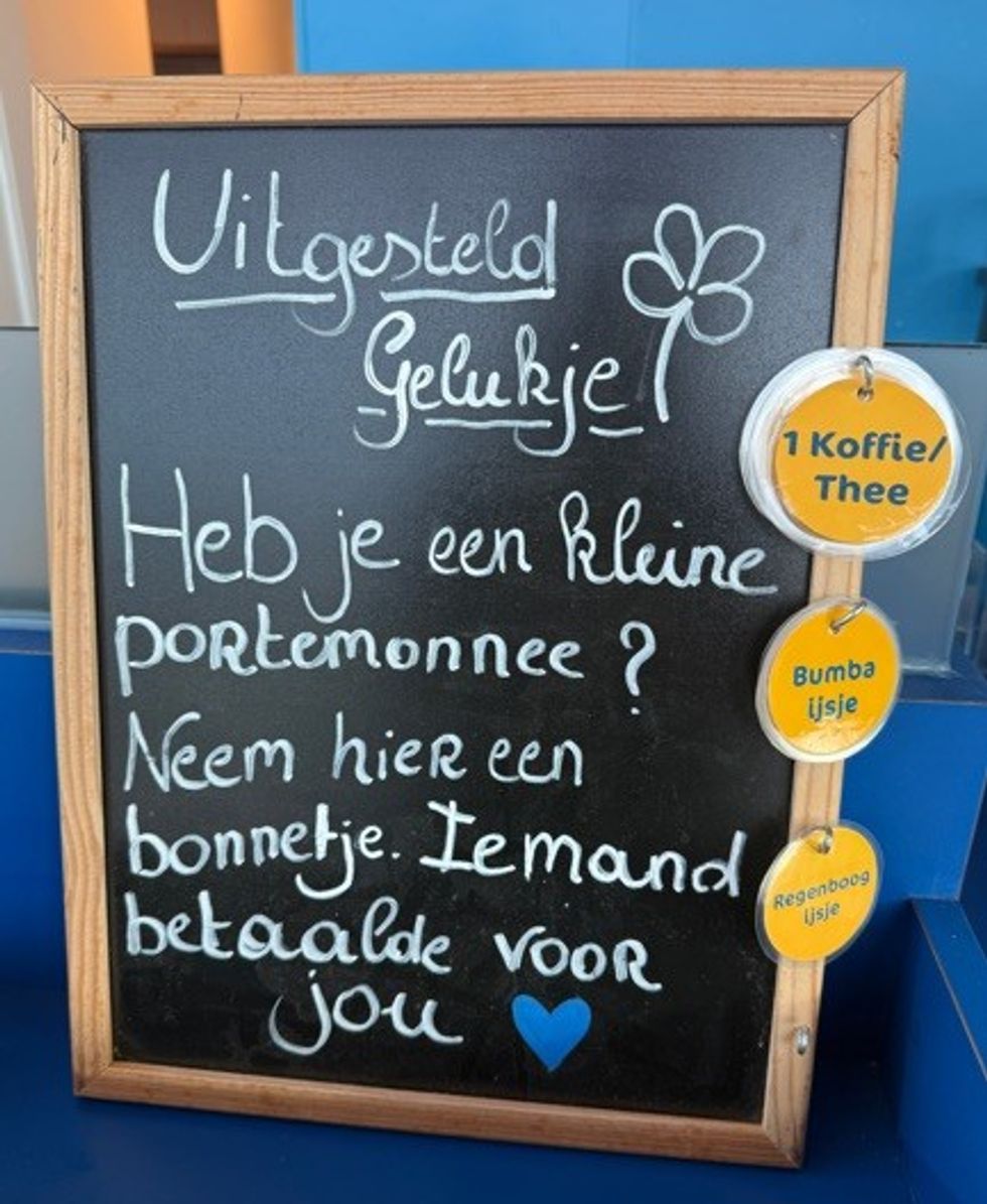 Chalkboard with Dutch text offering prepaid items like coffee and ice cream.
