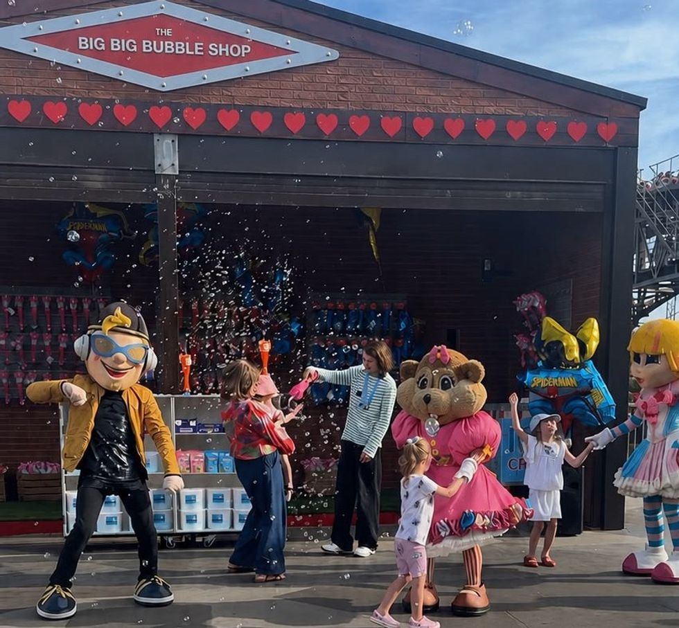 Characters and kids playing with bubbles in front of "The Big Big Bubble Shop."