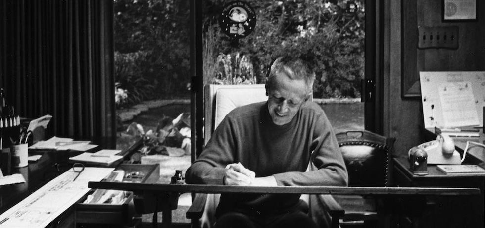 Charles M. Schulz, creator of Peanuts at his desk