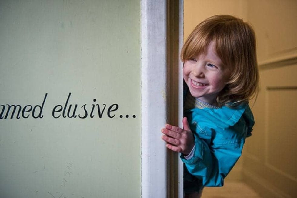 Child at The Story Museum peeking into a room
