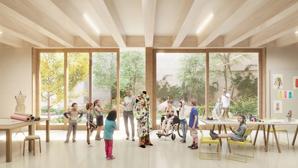 Children and adults gather in a bright, inclusive fashion design studio with large garden-facing windows.