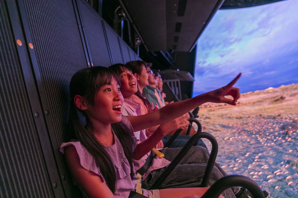 Children excitedly enjoying a simulated experience with vibrant visuals.