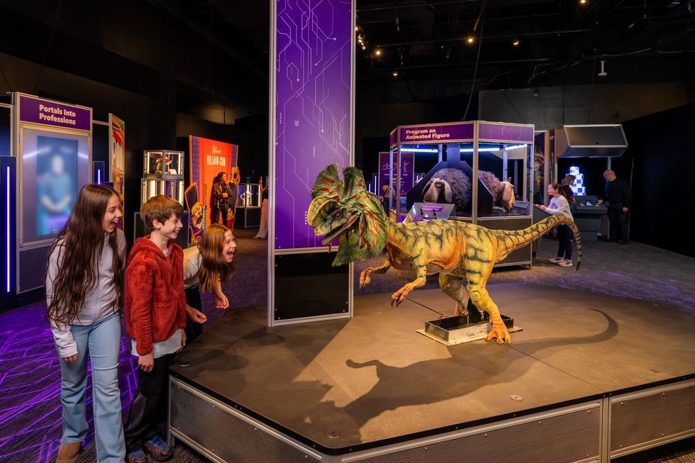 Children excitedly observe a dinosaur exhibit in the Franklin Institute science museum