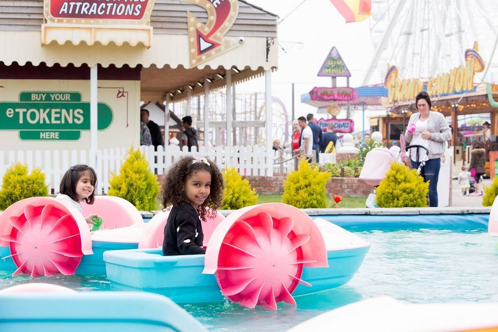 Children in pedal boats at a sunny amusement park in Southport, UK, named Adventure Coast