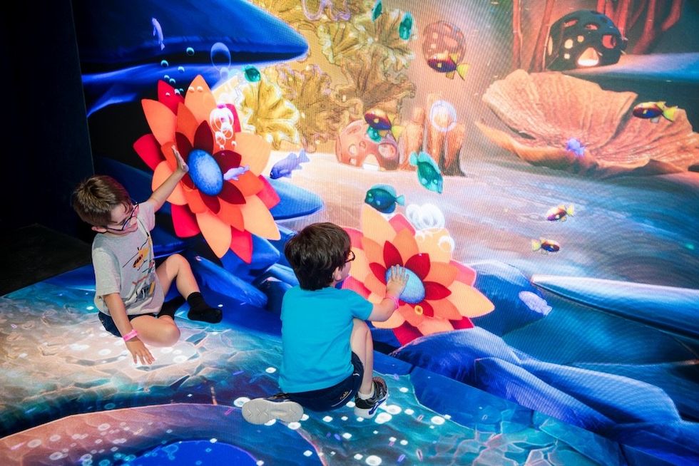 Children interact with an immersive underwater-themed digital exhibit.