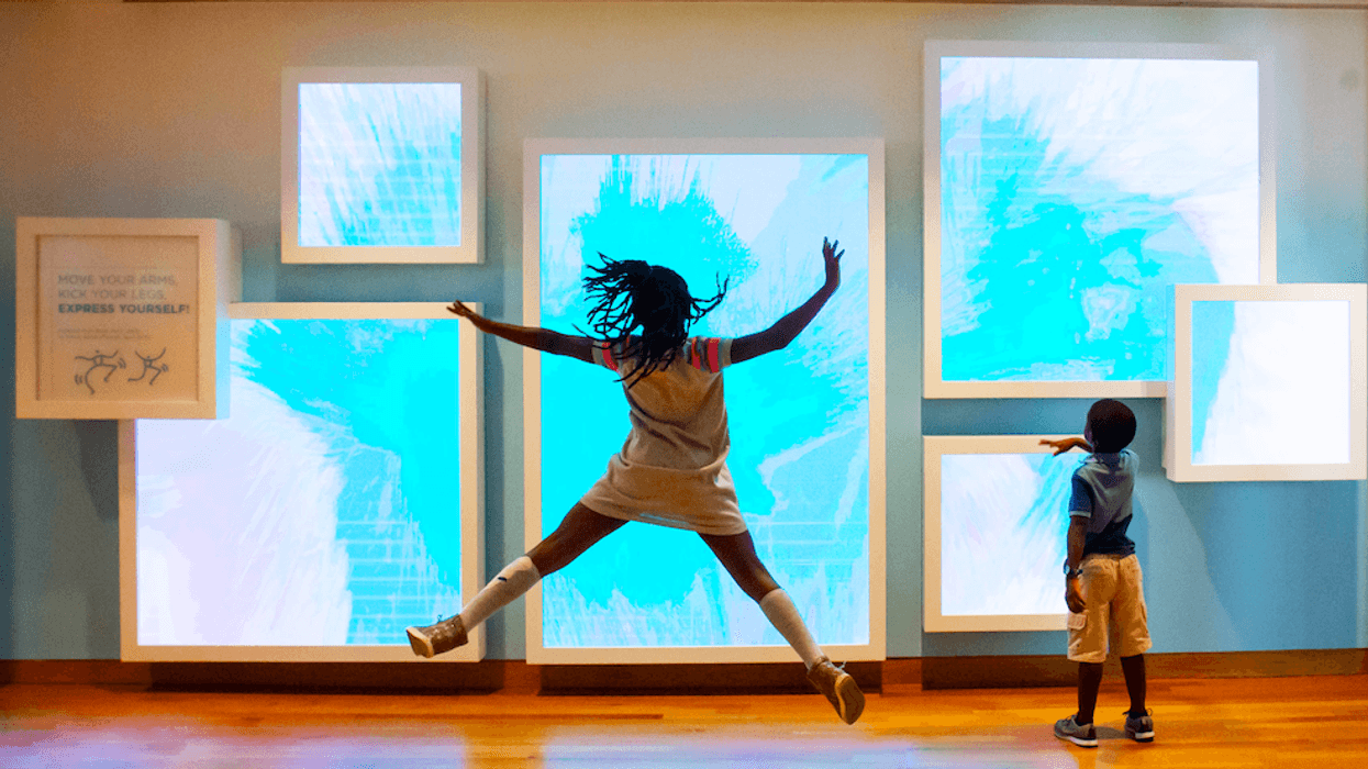 Children interact with dynamic blue screens in a gallery exhibit at High Museums