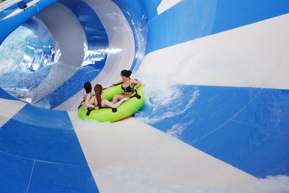 Children on water slide at aquapark. Summer holiday