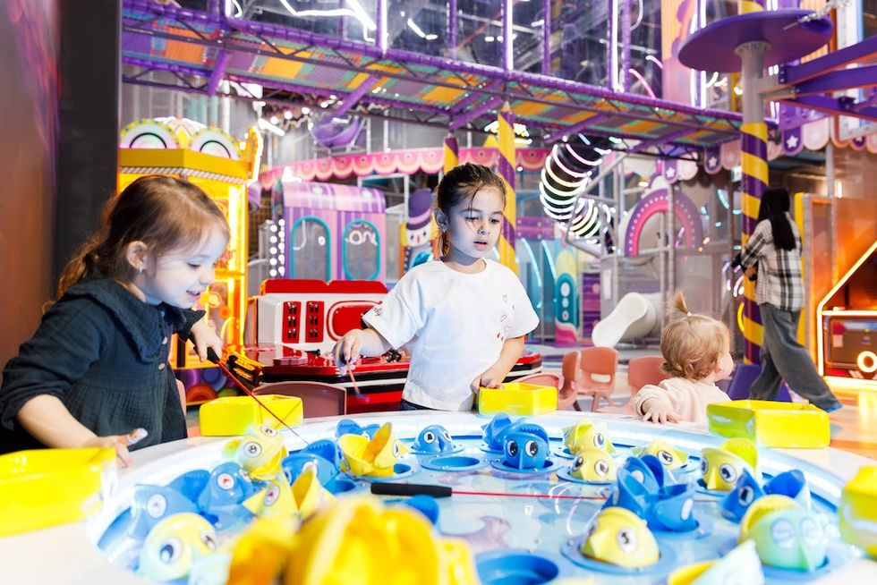 Children play fishing game in a colorful indoor playground, Funzy Playground, Romania