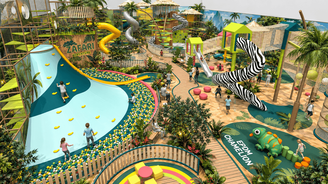 Children playing in jungle-themed indoor playground with slides and climbing areas.