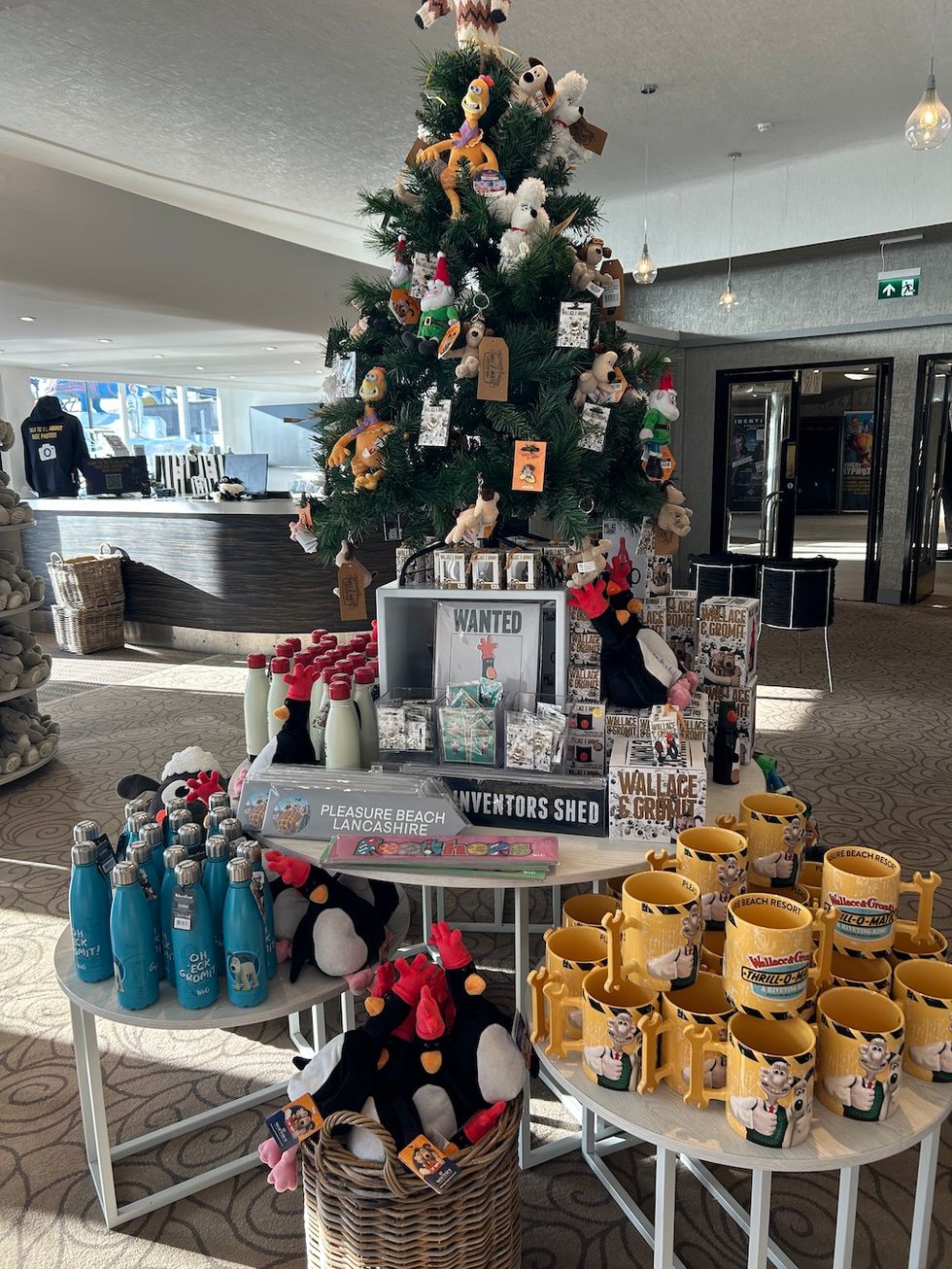 Christmas tree with toys and shelves of Wallace & Gromit merchandise in a shop.