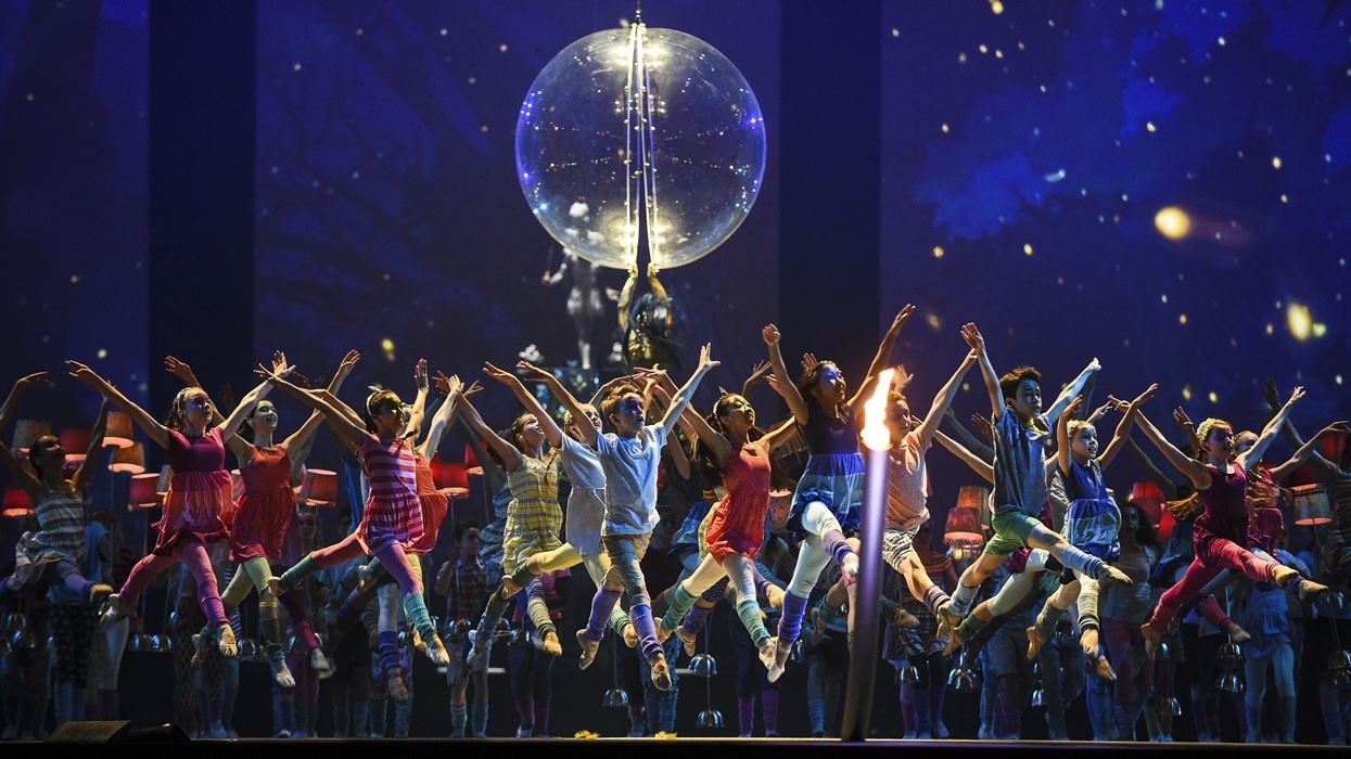 Cirque du Soleil dancers leap in unison onstage with a glowing globe and starry backdrop at the Pan American Games, Toronto 2015