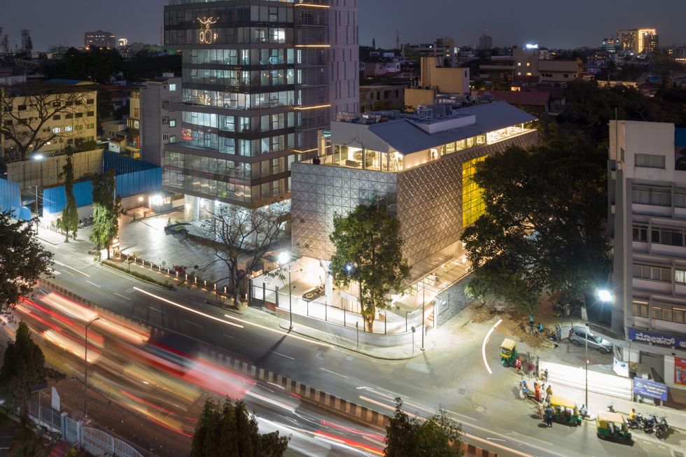 Cityscape with illuminated modern building called the Museum of Art & Photography and busy streets at night.