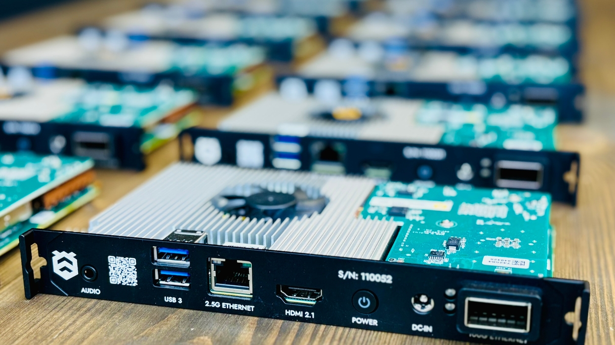 Close-up of circuit boards with USB, Ethernet, HDMI ports on a wooden table.