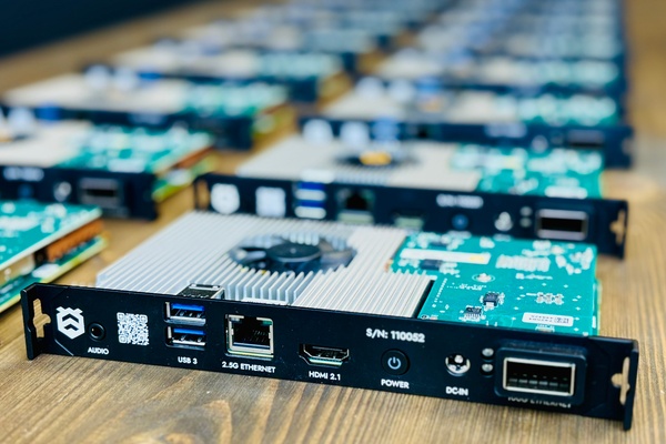 Close-up of circuit boards with USB, Ethernet, HDMI ports on a wooden table.