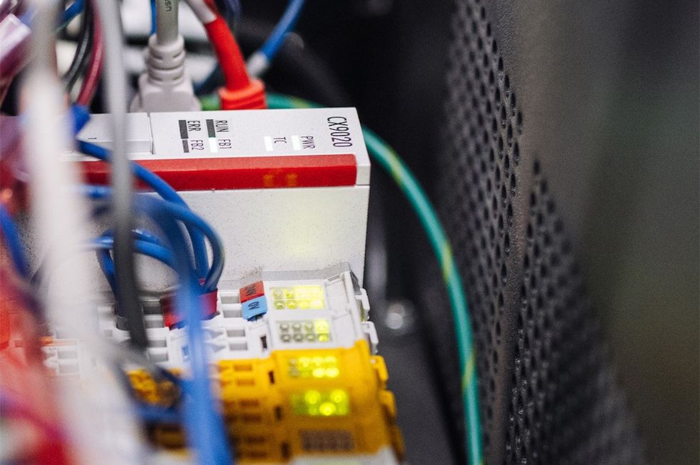Close-up of colorful network cables connected to a server with indicator lights.
