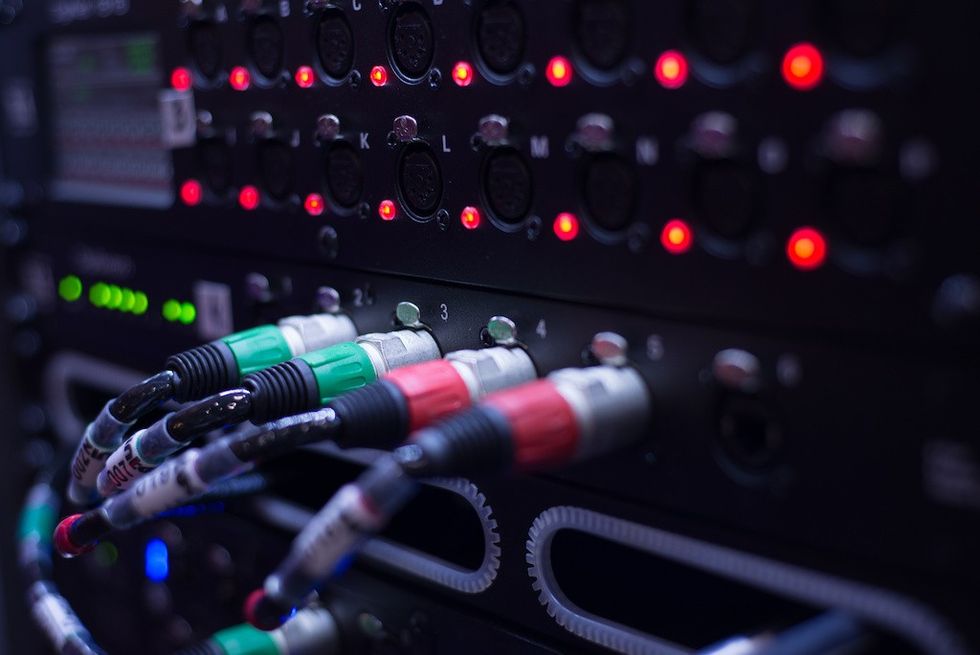 Close-up of server cables and glowing LED lights on a data rack.