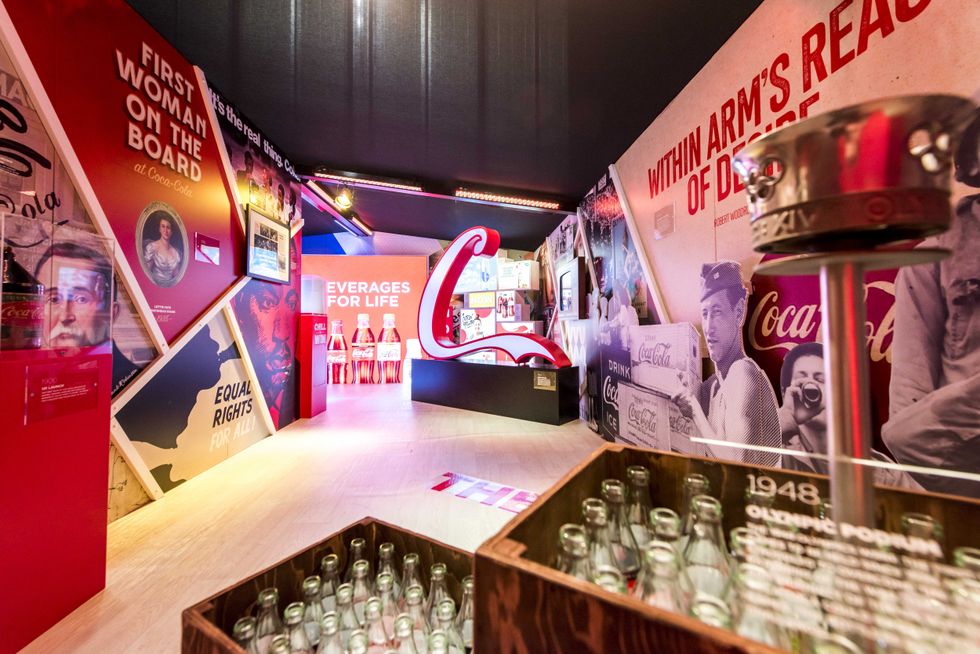 Coca-Cola exhibit with vintage posters, bottles, and "Beverages for Life" sign.