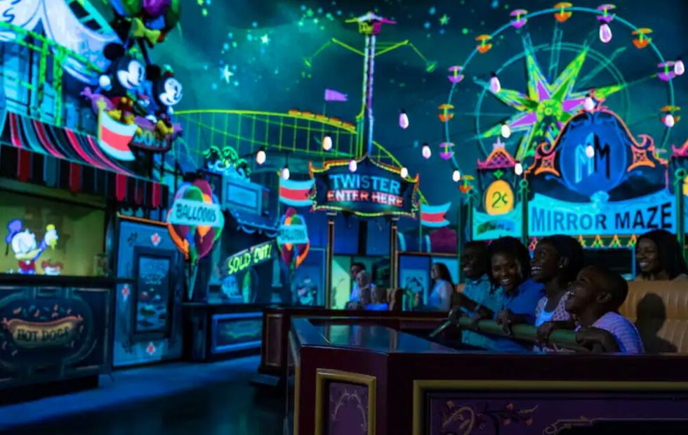 Colorful amusement park ride with families, neon decor, and animated characters - Mickey & Minnie's Runaway Railway