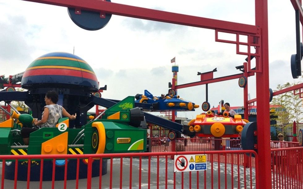 Colorful amusement park ride with people enjoying spaceship-themed vehicles.