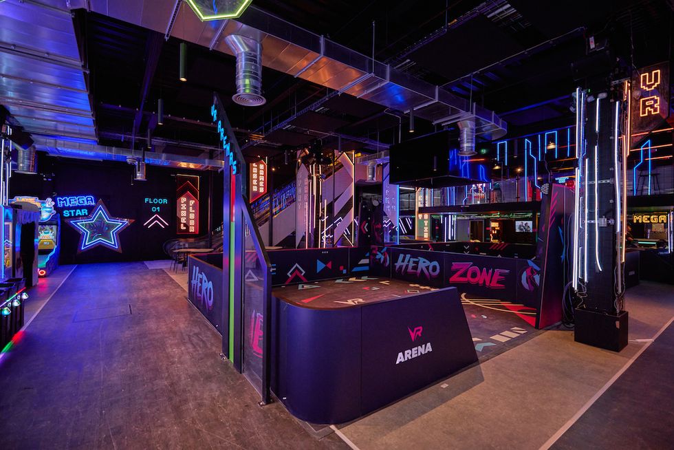 Colorful arcade with neon lights, VR arena, and gaming machines.