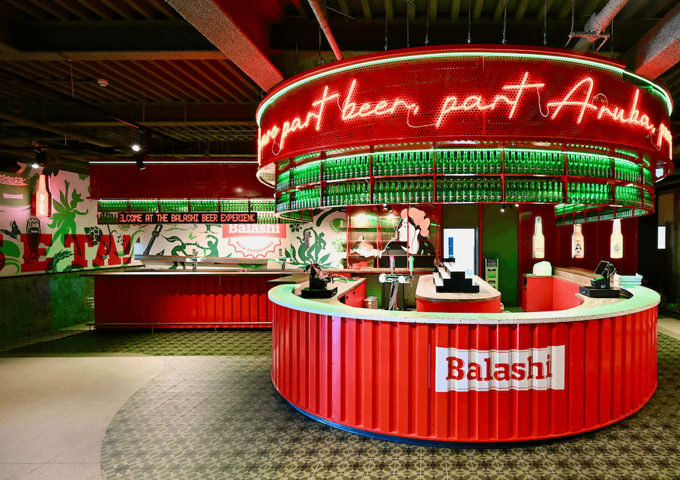 Colorful Balashi Beer bar with neon lights and decorative bottles on display.