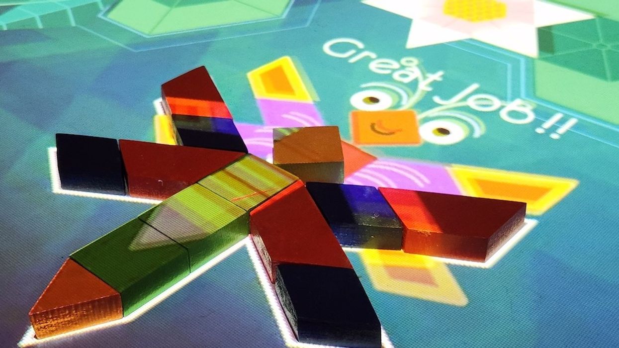 Colorful blocks form a butterfly on a digital surface with "Great Job!!" projected above.