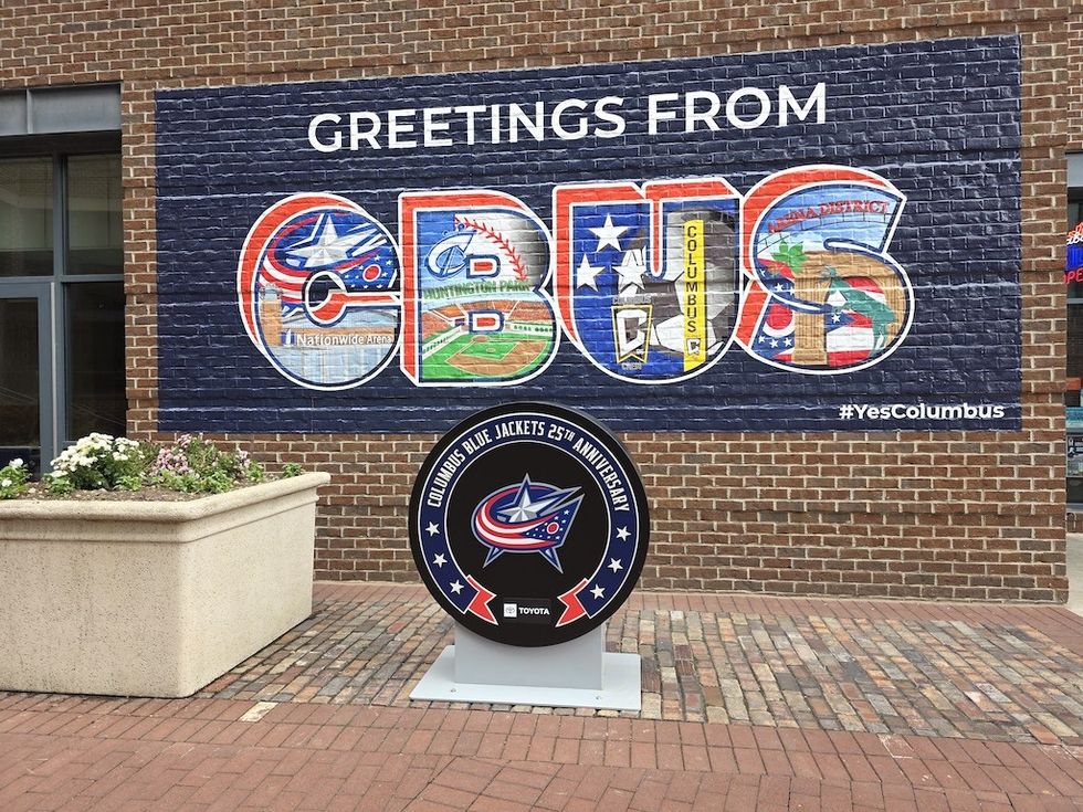 Colorful CBUS mural with sports and local scenes, celebrating Columbus Blue Jackets' anniversary.